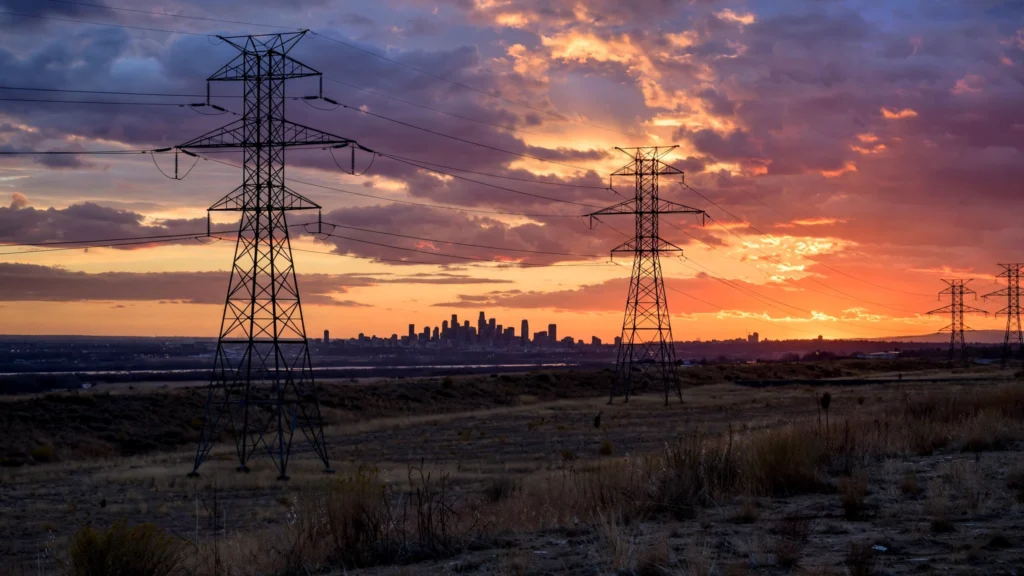 High-voltage power lines at sunset — blackout emergency order issued for the PJM power grid covering 13 states.